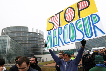 Menschen demonstrieren mit Schildern vor dem EU-Gebäude. Symbolbild: In Straßburg wird gegen das Mercosur-Abkommen demonstriert. Was dieses für Lohnabhängige in Österreich bedeutet. | © APA Images/Reuters/Yves Herman