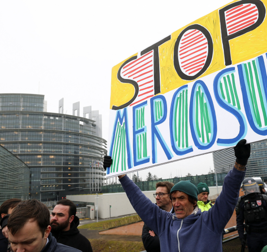 Menschen demonstrieren mit Schildern vor dem EU-Gebäude. Symbolbild: In Straßburg wird gegen das Mercosur-Abkommen demonstriert. Was dieses für Lohnabhängige in Österreich bedeutet. | © APA Images/Reuters/Yves Herman