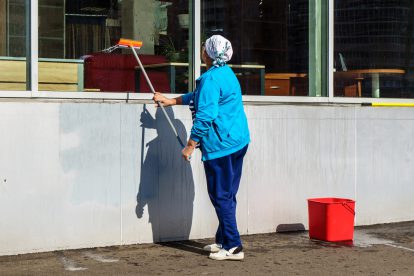 Eine weibliche Putzkraft reinigt eine Fensterfront. Symbolbild für einen Text von Sara Hassan und Josefa Niedermaier.