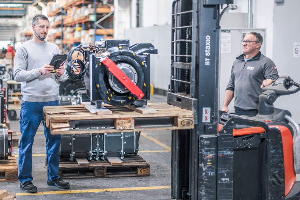 Zwei Männer arbeiten in einer Werkstatt. Symbolbild: In der Werkshalle: Der Konzern TSA in Wiener Neudorf ist Weltmarktführer im Bereich elektromechanischer Antriebe für Schienenfahrzeuge.