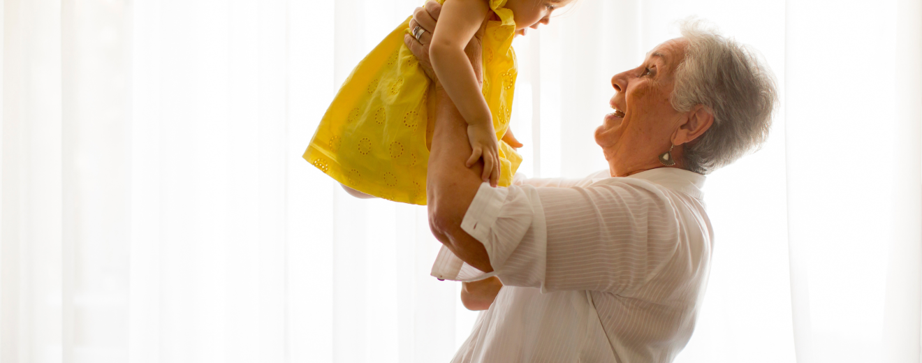 Eine Oma hebt ihre Enkelin in die Luft. Symbolbild: Die Pensionslücke beginnt lange bevor Frauen in den Berufsalltag einsteigen. | © Adobestock/BGStock72