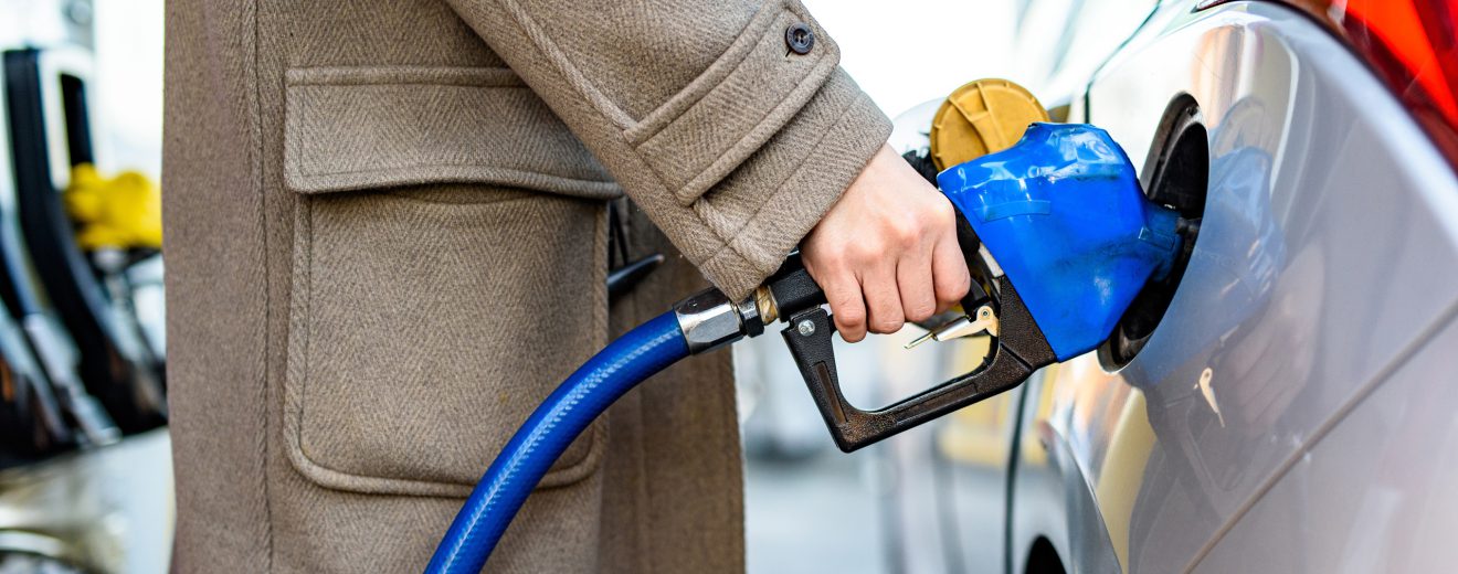 Person hält einen blauen Zapfhahn in der Hand. Symbolbild für die Spritpreisbremse in Österreich.