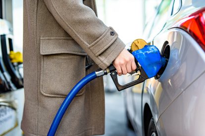 Person hält einen blauen Zapfhahn in der Hand. Symbolbild für die Spritpreisbremse in Österreich.