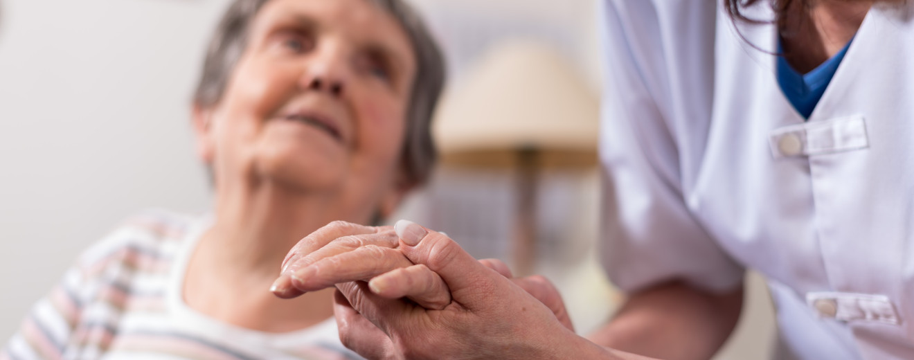 Eine alte Frau wird von einer Pflegekraft an der Hand gehalten. Symbolbild: Am Tag der Pflege erzählen fünf Pflegekräfte über ihren Berufsalltag.
