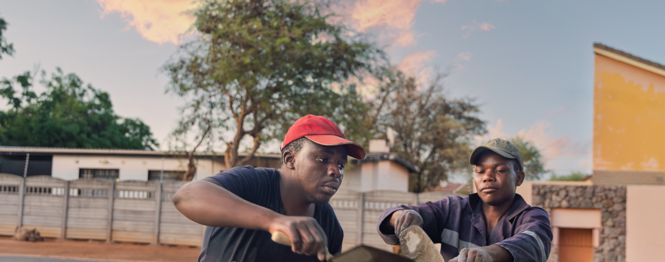 Zwei Männer arbeiten in Afrika an einer Mauer. Symbolbild: Wie sind die Arbeitsbedingungen in Afrika und wie arbeitet die Gewerkschaft daran die Ungleichheit zu reduzieren? | © Adobestock/poco_bw