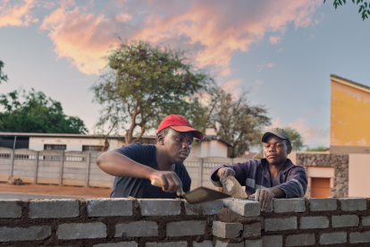Zwei Männer arbeiten in Afrika an einer Mauer. Symbolbild: Wie sind die Arbeitsbedingungen in Afrika und wie arbeitet die Gewerkschaft daran die Ungleichheit zu reduzieren? | © Adobestock/poco_bw
