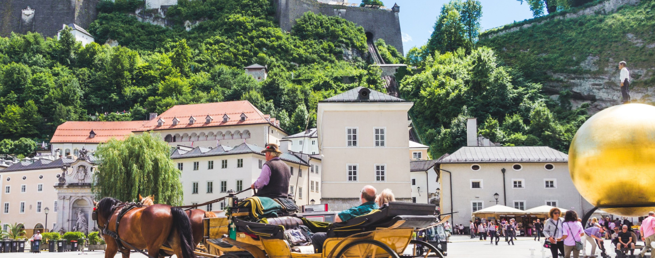 Salzburg vor der Festung mit einer Pferdekutsche. Symbolbild für Tourismus in Österreich.