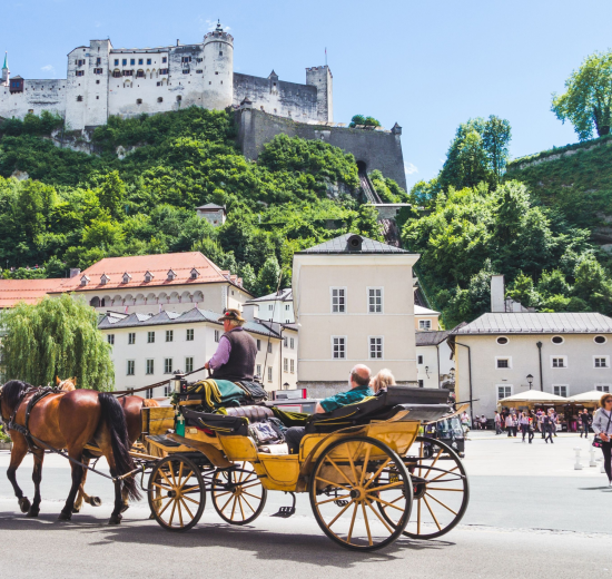 Salzburg vor der Festung mit einer Pferdekutsche. Symbolbild für Tourismus in Österreich.
