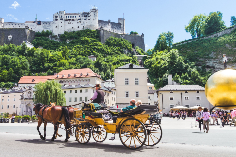 Salzburg vor der Festung mit einer Pferdekutsche. Symbolbild für Tourismus in Österreich.