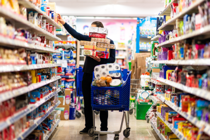 Ein Mann türmt Lebensmittel in seinen Einkaufswagen. Symobilbild für: Könnte das Chaos am Samstag im Supermarkt durch andere Öffnungszeiten vermieden werden?