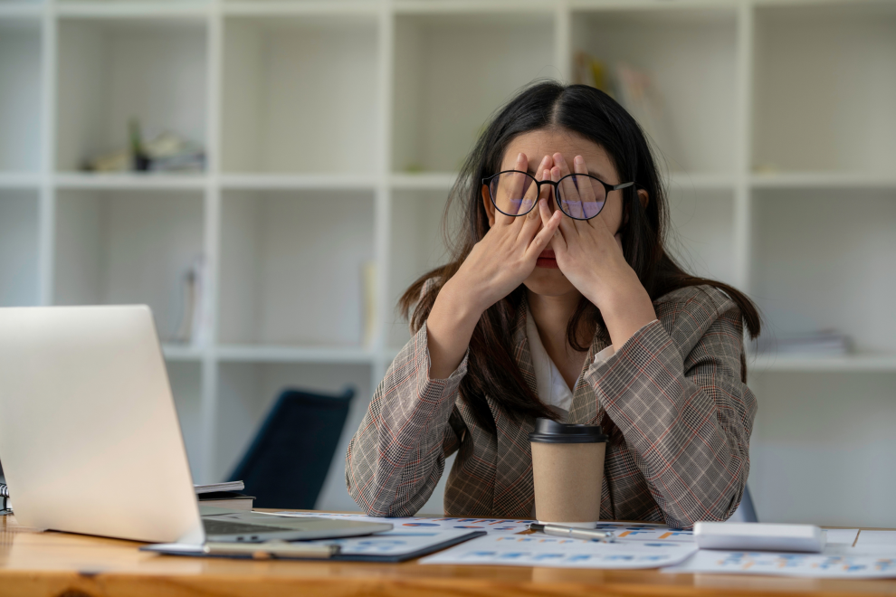 Eine Frau im Büro schlägt verzweifelt die Hände vors Gesicht. Symbolbild: Die Belastungen für Betriebsrät:innen nehmen stetig zu.